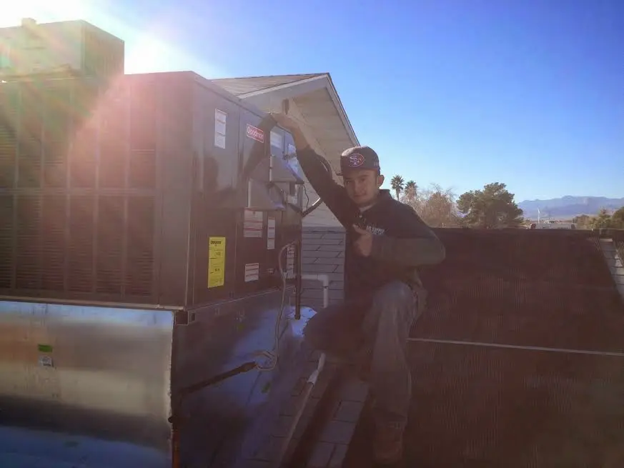 HVAC technician performing AC Tune-Up on a rooftop unit in Marlene Village